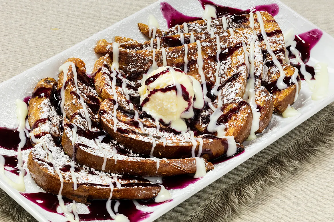 Crunchberry French Toast — Texas toast rolled in Crunchberry cereal with blueberry jelly, cream cheese icing and powdered sugar
