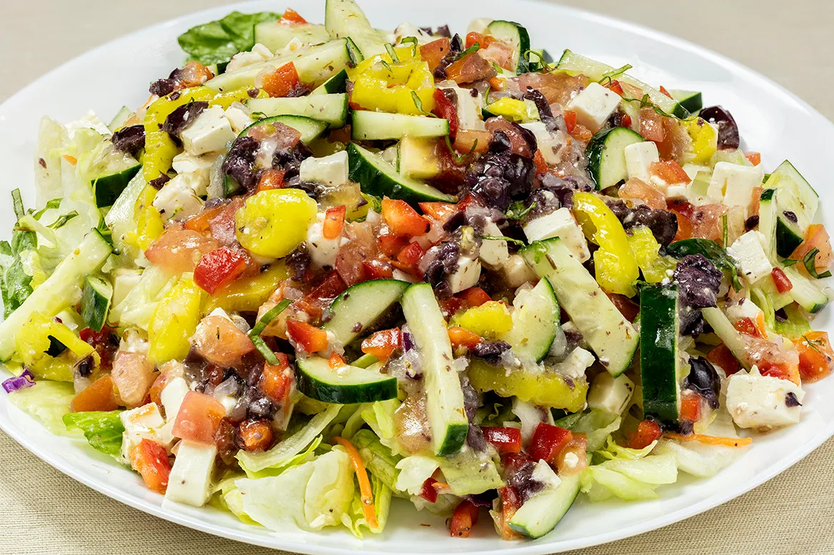 Greek Salad — diced tomato, red peppers, pepperoncini, Kalamata olives, cucumber and feta cheese tossed in a Greek dressing